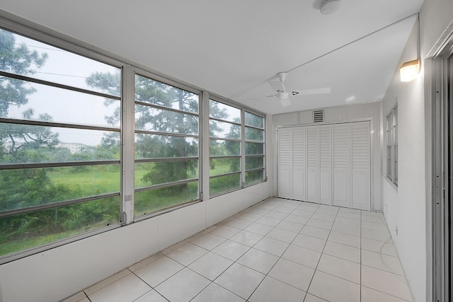 unfurnished sunroom featuring a wealth of natural light and ceiling fan