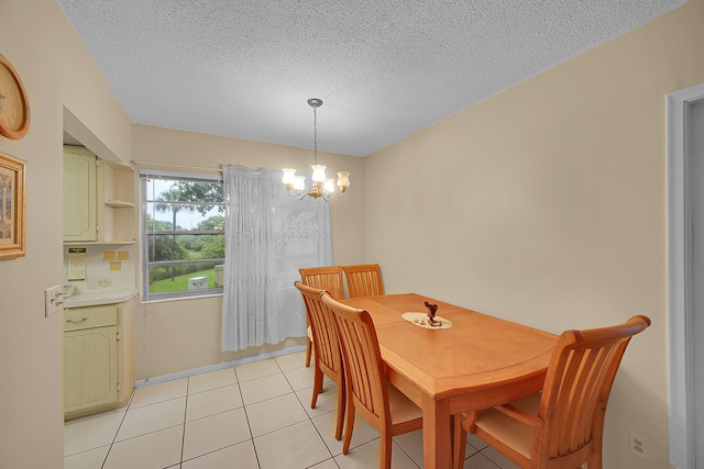 tiled dining room with a textured ceiling and a notable chandelier