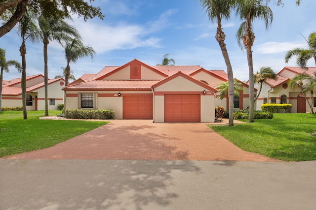 mediterranean / spanish house with a front lawn and a garage