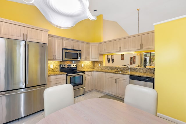 kitchen featuring light brown cabinets, backsplash, light tile floors, high vaulted ceiling, and appliances with stainless steel finishes