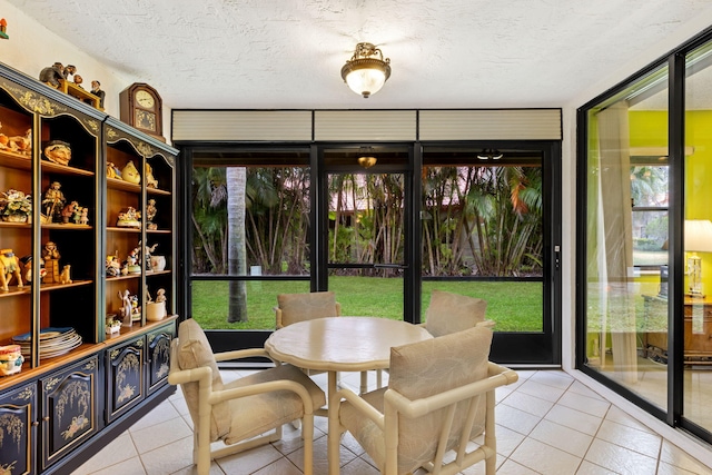 tiled dining area featuring a wealth of natural light, a wall of windows, and a textured ceiling