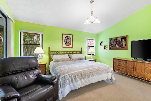 carpeted bedroom featuring vaulted ceiling and an inviting chandelier