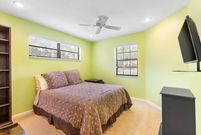 bedroom featuring carpet flooring, ceiling fan, and a textured ceiling