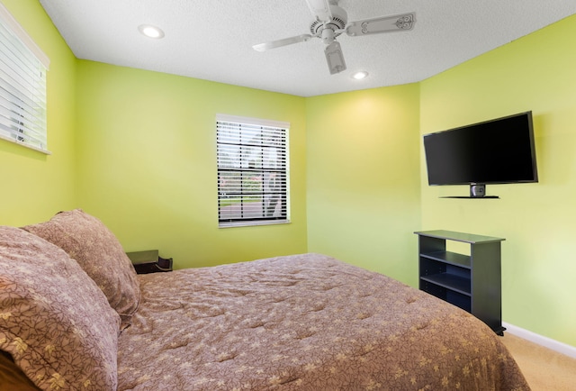 carpeted bedroom with a textured ceiling and ceiling fan