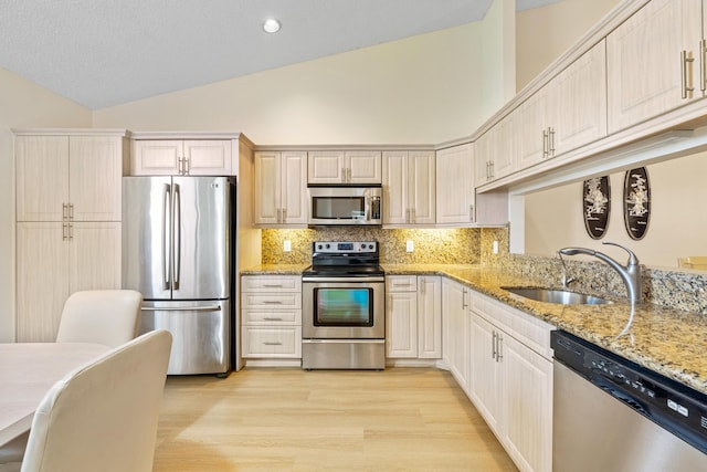 7825 Lexington Club Blvd Unit B, Delray Beach, FL 33446 - kitchen featuring light stone countertops, light wood-style flooring, a sink, and appliances with stainless steel finishes