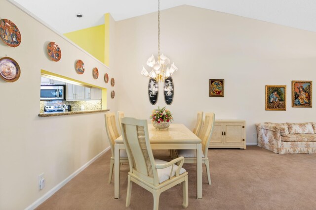 carpeted dining area with high vaulted ceiling and an inviting chandelier