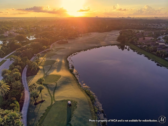 aerial view at dusk featuring a water view