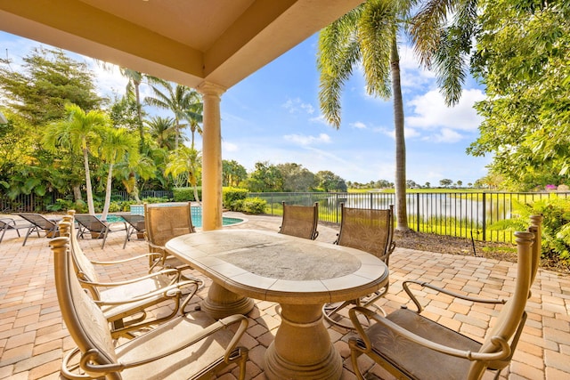 view of patio featuring a fenced in pool and a water view