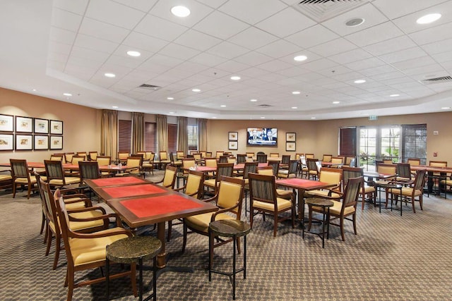 dining space featuring carpet and a raised ceiling