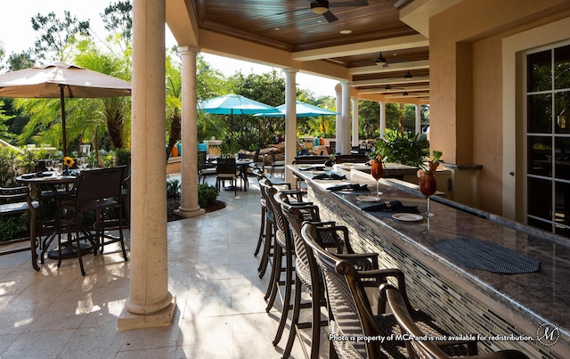 view of patio featuring exterior bar and ceiling fan