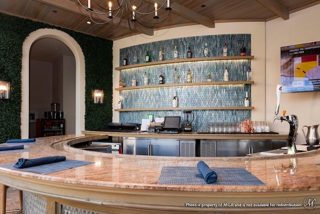 bar with sink, light stone counters, beamed ceiling, a notable chandelier, and wood ceiling