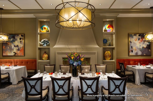 dining space featuring built in shelves, an inviting chandelier, and crown molding