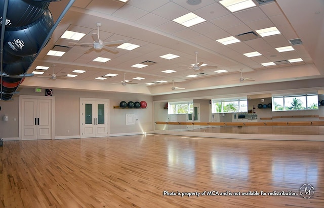 workout area featuring hardwood / wood-style floors and a drop ceiling