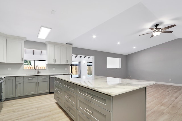 kitchen with a sink, light wood-type flooring, a kitchen island, and gray cabinetry