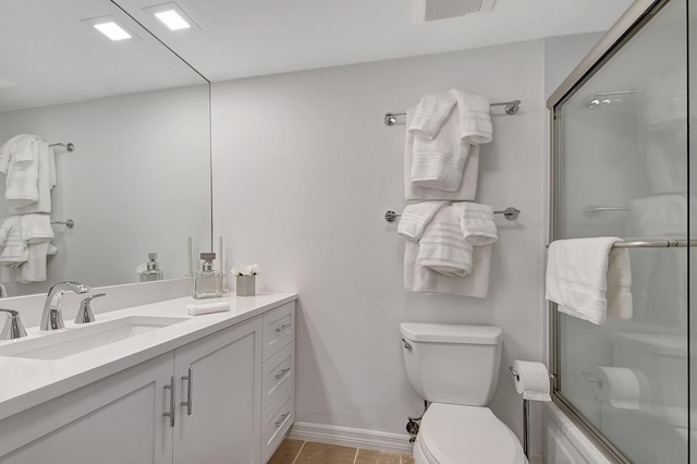 full bathroom with shower / bath combination with glass door, tile patterned floors, vanity, and toilet