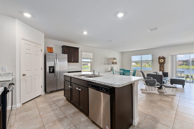 kitchen with a wealth of natural light, sink, a kitchen island with sink, and stainless steel appliances