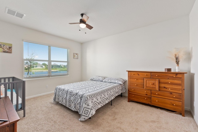 bedroom featuring light colored carpet and ceiling fan