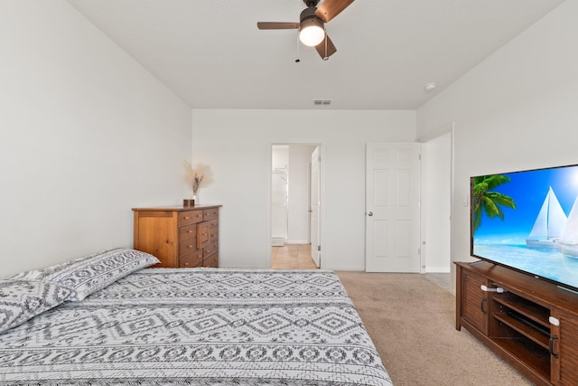 bedroom featuring connected bathroom, ceiling fan, and light carpet