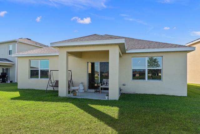 back of property with a yard and a patio