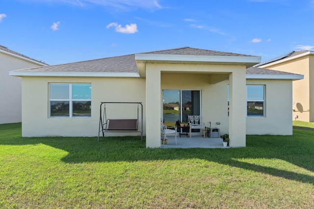 rear view of property featuring a yard and a patio