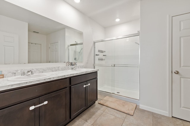 bathroom featuring a shower with door, vanity, and tile patterned floors