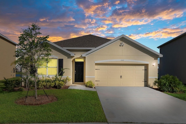 ranch-style home with a garage and a lawn