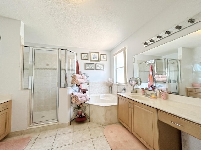 bathroom featuring tile floors, a textured ceiling, separate shower and tub, and vanity