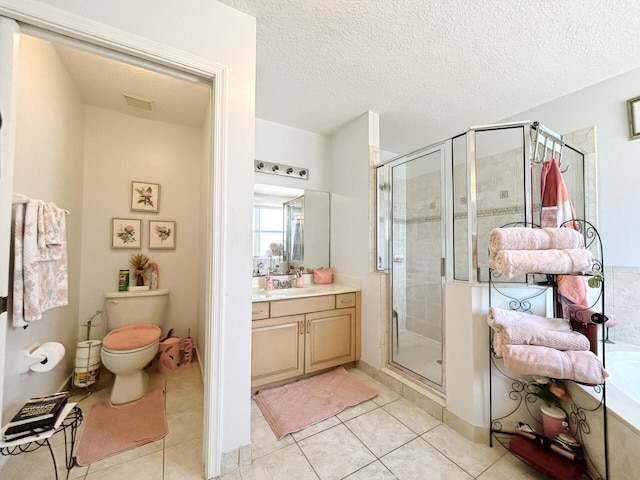 bathroom with tile flooring, a shower with door, a textured ceiling, toilet, and vanity