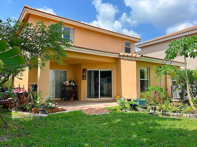 back of property featuring a patio area and a lawn