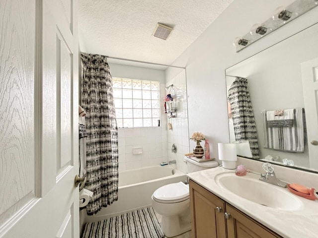 full bathroom featuring a textured ceiling, shower / bath combo with shower curtain, toilet, and vanity