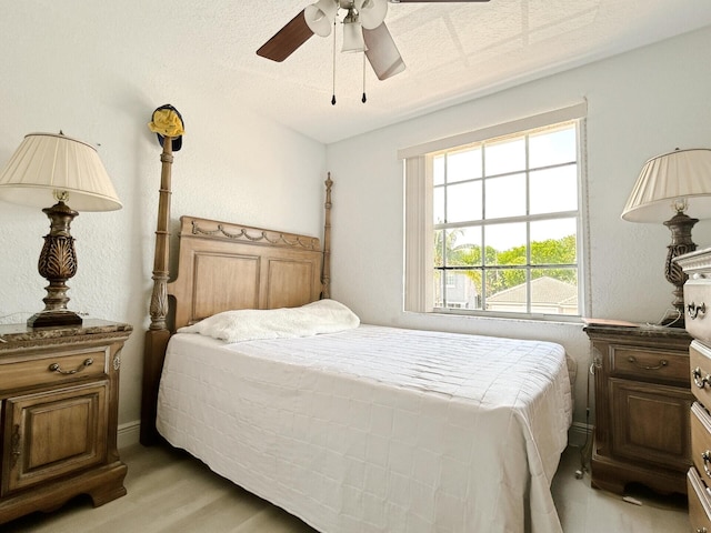 bedroom featuring a textured ceiling, light wood-type flooring, and ceiling fan