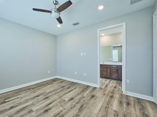 unfurnished bedroom with ceiling fan, sink, ensuite bathroom, and light wood-type flooring