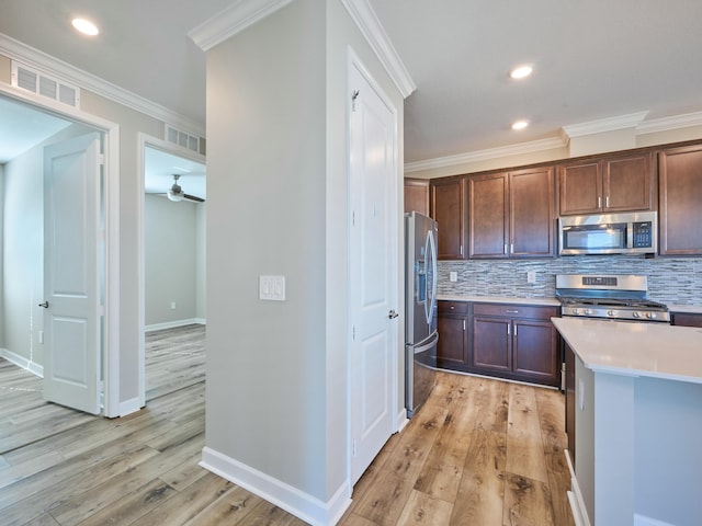 kitchen featuring light hardwood / wood-style flooring, ceiling fan, ornamental molding, appliances with stainless steel finishes, and dark brown cabinets