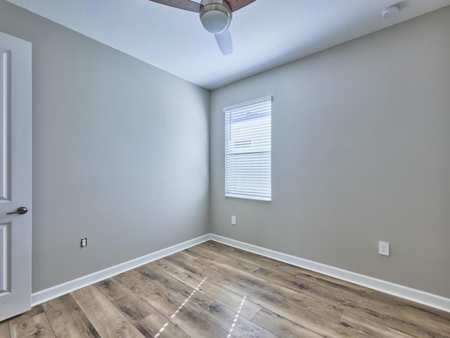 empty room with ceiling fan and light hardwood / wood-style floors