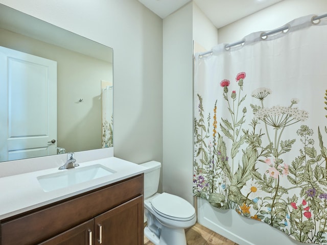 full bathroom with hardwood / wood-style flooring, vanity, toilet, and shower / bath combo with shower curtain