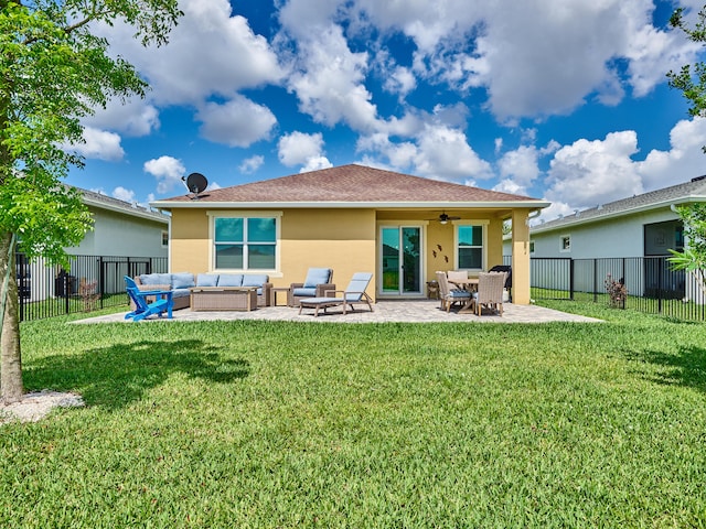 rear view of property featuring outdoor lounge area, ceiling fan, a patio area, and a lawn