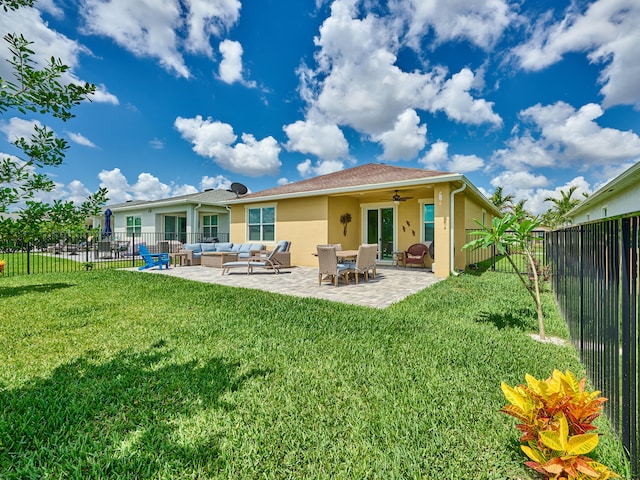 back of property with a lawn, a patio area, ceiling fan, and an outdoor hangout area