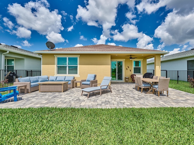 rear view of property featuring ceiling fan, a patio area, an outdoor hangout area, and a yard