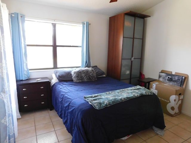 bedroom with ceiling fan and light tile floors