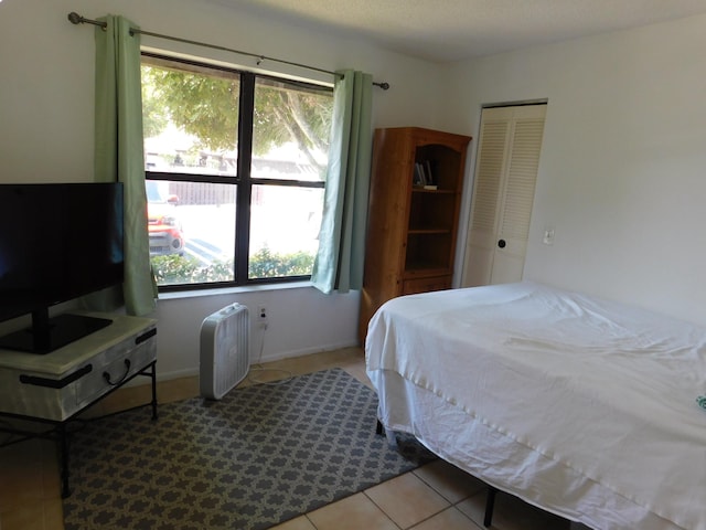 bedroom featuring tile flooring and a closet