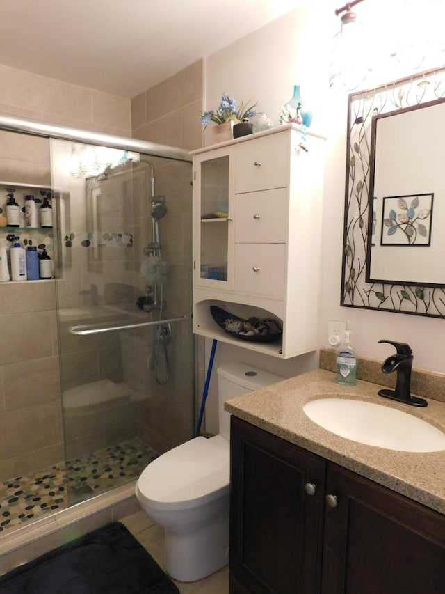 bathroom featuring an enclosed shower, vanity, toilet, and tile floors