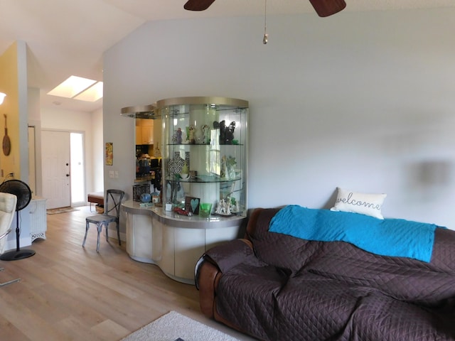 living room featuring high vaulted ceiling, ceiling fan, and light wood-type flooring