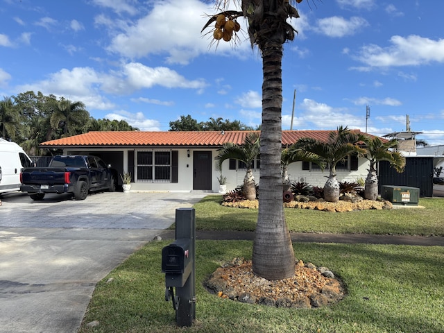 view of front facade with a carport, a front lawn, and cooling unit