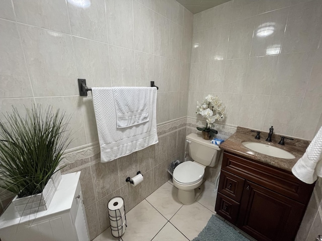 bathroom with tile patterned floors, vanity, toilet, and tile walls