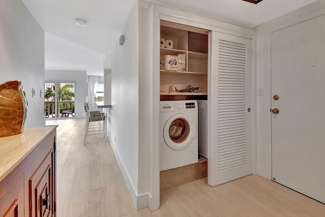 laundry area with light hardwood / wood-style flooring and washer / dryer