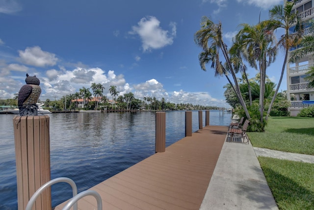 view of dock with a water view and a lawn