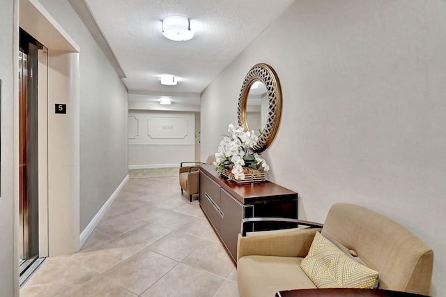 hallway with light tile patterned flooring and a textured ceiling