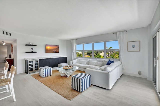 living room with hardwood / wood-style flooring and beverage cooler