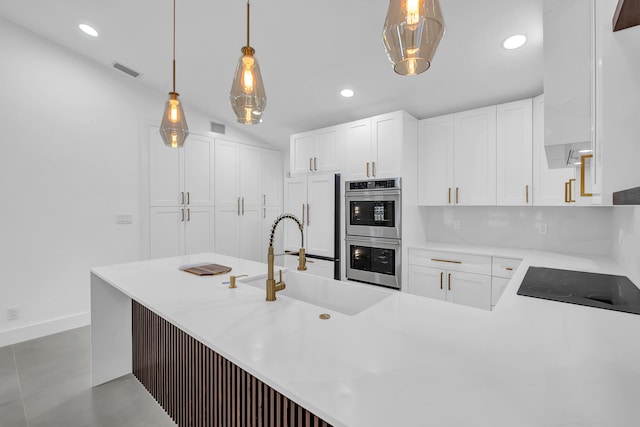 kitchen featuring decorative light fixtures, white cabinetry, double oven, and black electric cooktop