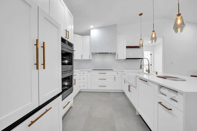 kitchen with custom exhaust hood, sink, white cabinetry, and light tile floors